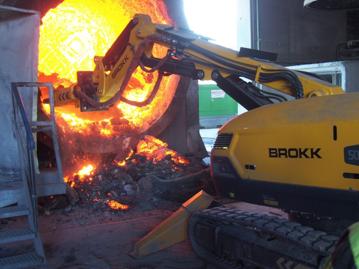 Remote-controlled robot clearing a furnace tap hole